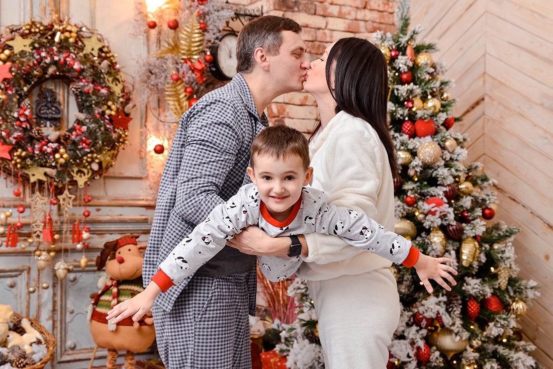 Родители и сын играют на новогодней фотосессии